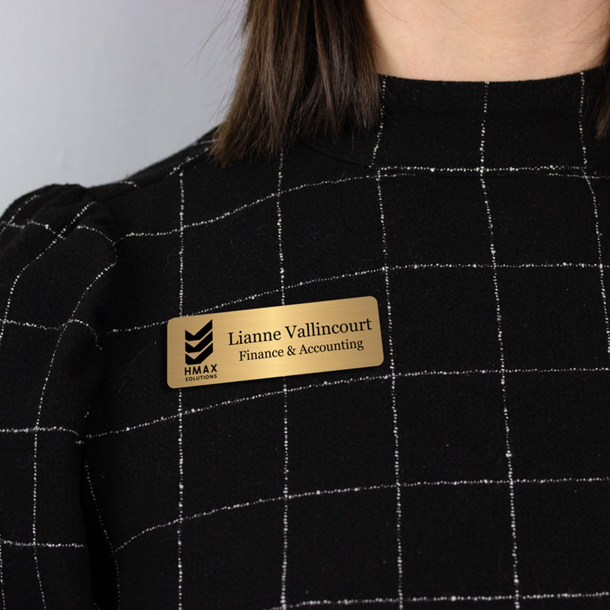 Gold name tag - finance and accounting - worn on a black windowpane top for perspective