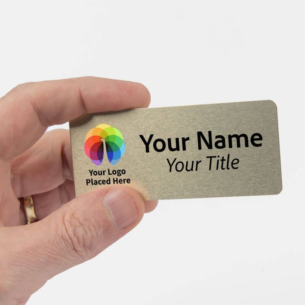A hand holding a 1.5 x 3.5 Gold Name Tag