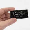 Black name tag in hand