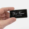 Black name tag in hand