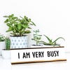 White desk plate with black custom text in rose gold holder on a desk