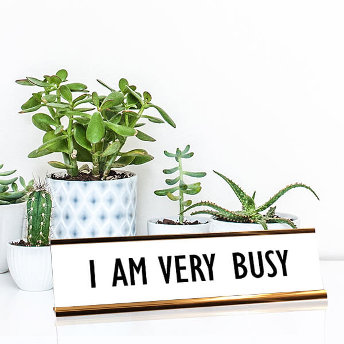 White desk plate with black custom text in rose gold holder on a desk