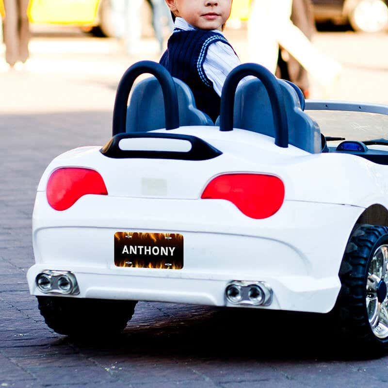 A White Toy Car with a Mini License Plate with a Flame Design
