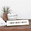 White desk plate with black custom text in a gold holder on desk