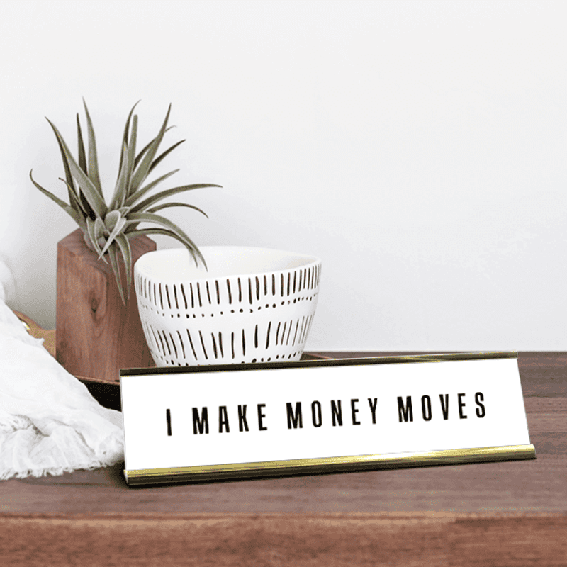 White desk plate with black custom text in a gold holder on desk