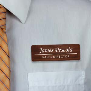 Engraved Plastic Custom Name Tag in Traditional Serif Font on White Shirt with Orange Tie