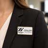 1.5x3 executive engraved name badge with gold beveled frame worn on black blazer — professional name tag with logo for corporate employees