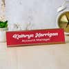 Kathryn Harrigan in Bold Script Style, Red with White Letters Desk Plate on Office Setting With Marble Background